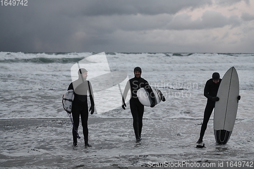 Image of Arctic surfers going by beach after surfing