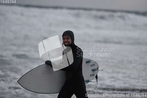 Image of Arctic surfer going by beach after surfing