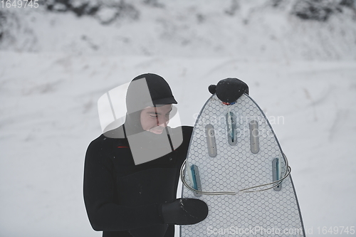 Image of Arctic surfer portrait holding a board after surfing in Norwegian sea