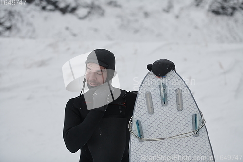 Image of Arctic surfer portrait holding a board after surfing in Norwegian sea