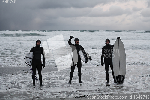 Image of Arctic surfers going by beach after surfing
