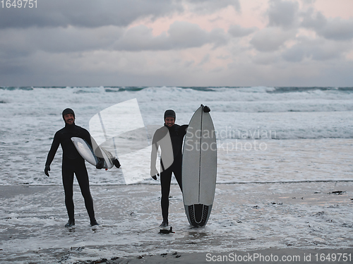 Image of Arctic surfers going by beach after surfing