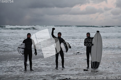 Image of Arctic surfers going by beach after surfing