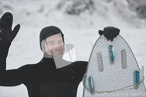 Image of Arctic surfer portrait holding a board after surfing in Norwegian sea