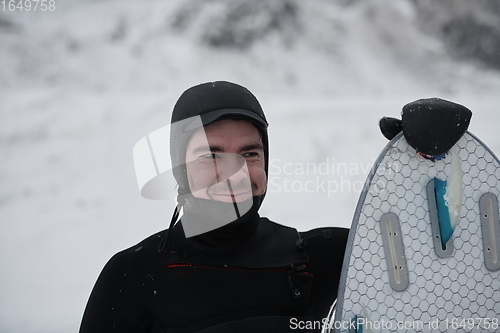 Image of Arctic surfer portrait holding a board after surfing in Norwegian sea