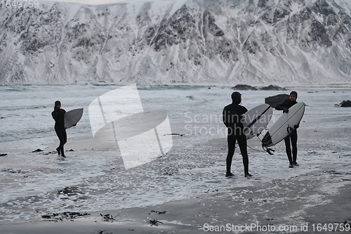 Image of Arctic surfers going by beach after surfing