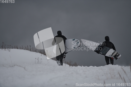 Image of Arctic surfers running on beach after surfing