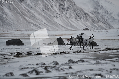 Image of Arctic surfers going by beach after surfing