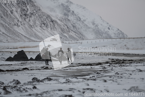 Image of Arctic surfers going by beach after surfing