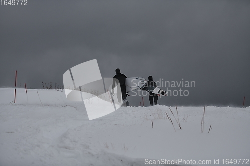 Image of Arctic surfers running on beach after surfing