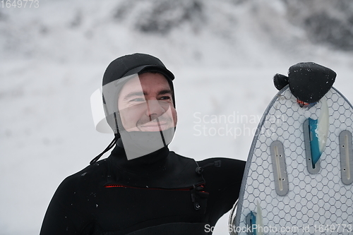 Image of Arctic surfer portrait holding a board after surfing in Norwegian sea