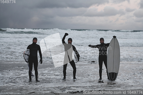 Image of Arctic surfers going by beach after surfing