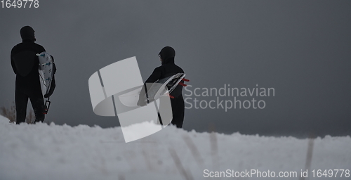 Image of Arctic surfers running on beach after surfing