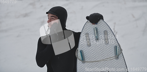 Image of Arctic surfer portrait holding a board after surfing in Norwegian sea