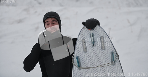 Image of Arctic surfer portrait holding a board after surfing in Norwegian sea