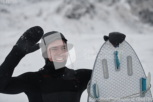 Image of Arctic surfer portrait holding a board after surfing in Norwegian sea