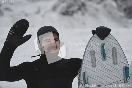 Image of Arctic surfer portrait holding a board after surfing in Norwegian sea