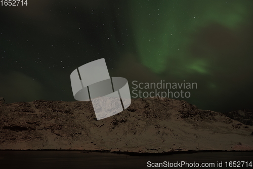 Image of Aurora borealis Green northern lights above mountains