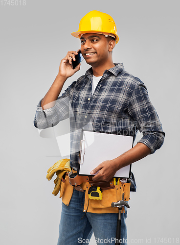 Image of indian builder in helmet calling on smartphone