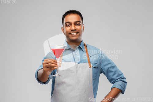 Image of indian barman in apron with glass of cocktail