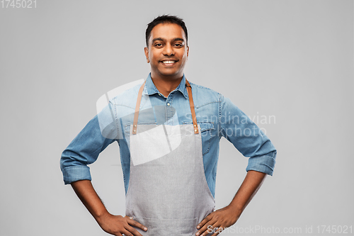 Image of smiling indian barman, waiter or salesman in apron