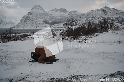 Image of Muslim traveler praying in cold snowy winter day