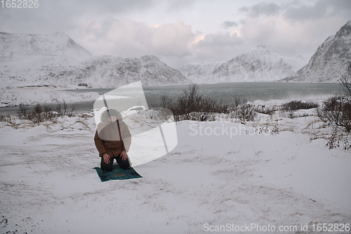 Image of Muslim traveler praying in cold snowy winter day