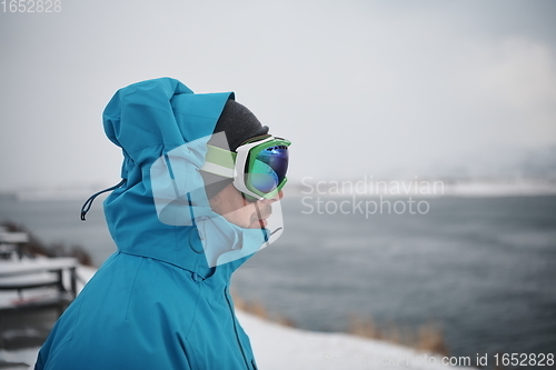 Image of man at winter in stormy weather night wearing warm fur jacket