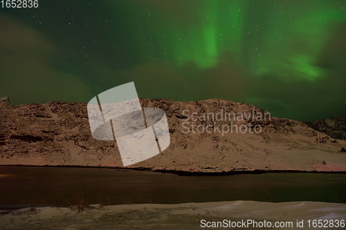 Image of Aurora borealis Green northern lights above mountains