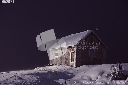 Image of Traditional Norwegian fisherman\'s cabins covered with snow at night