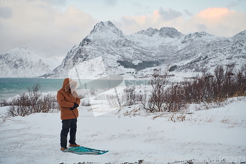 Image of Muslim traveler praying in cold snowy winter day