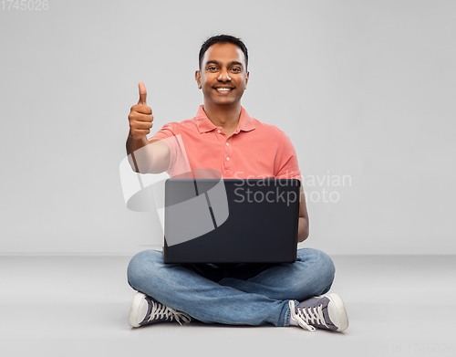 Image of happy indian man with laptop showing thumbs up