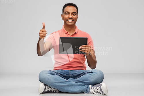 Image of happy indian man with tablet pc showing thumbs up