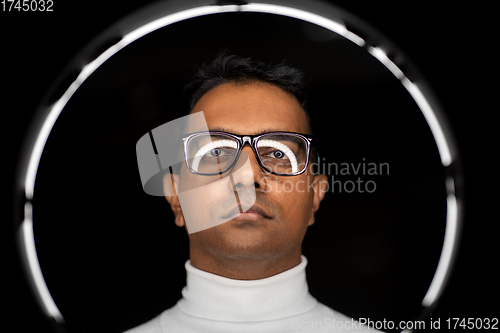 Image of man in glasses with white illumination over black