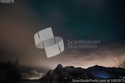 Image of Aurora borealis Green northern lights above mountains