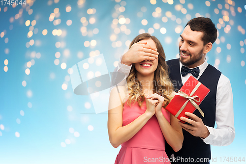 Image of happy man giving woman surprise present