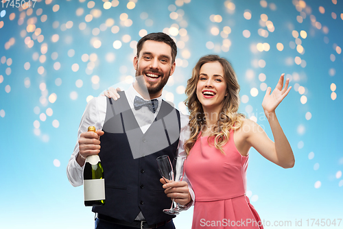 Image of happy couple with bottle of champagne and glasses