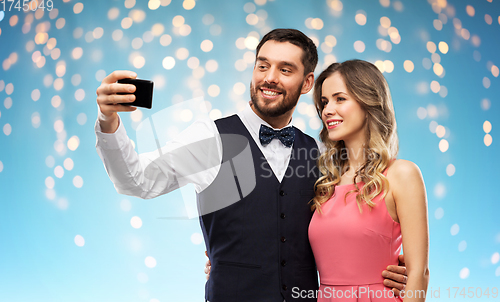 Image of happy couple taking selfie by smartphone