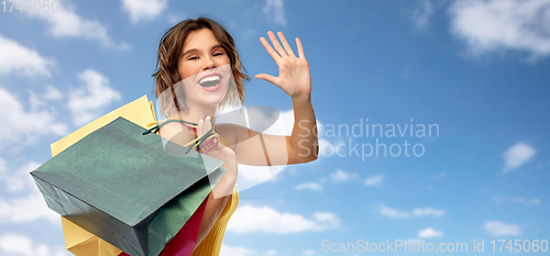 Image of happy smiling young woman with shopping bags