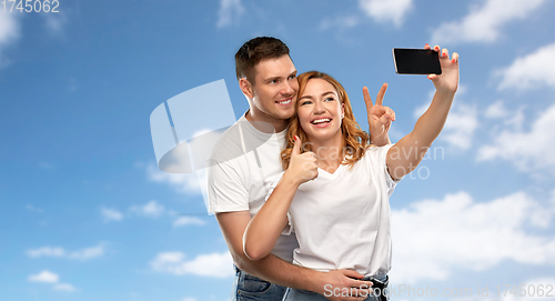 Image of happy couple in white t-shirts taking selfie