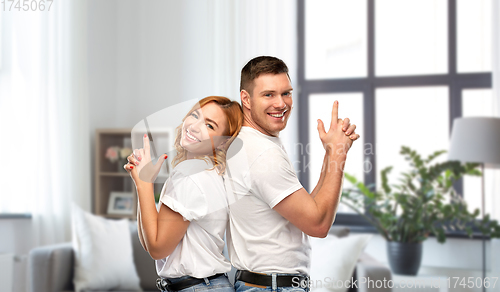 Image of couple in white t-shirts shirts making gun gesture