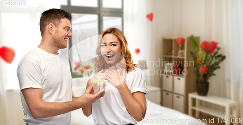 Image of happy couple with gift at home