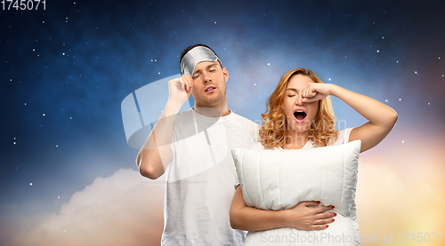 Image of couple with eye sleeping mask and pillow at night