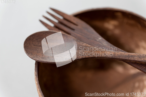 Image of close up of coconut bowl, wooden spoon and fork