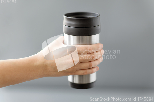 Image of hand holding tumbler mug or thermo cup