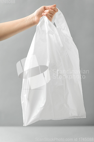 Image of woman holding white disposable plastic bag