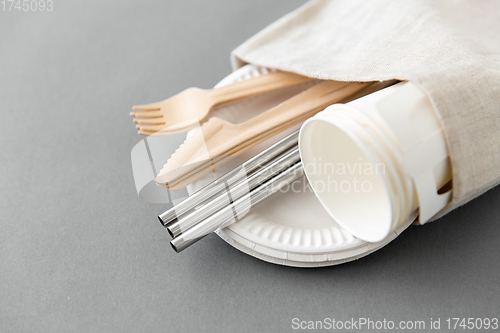 Image of wooden forks, knives and paper cups on plate