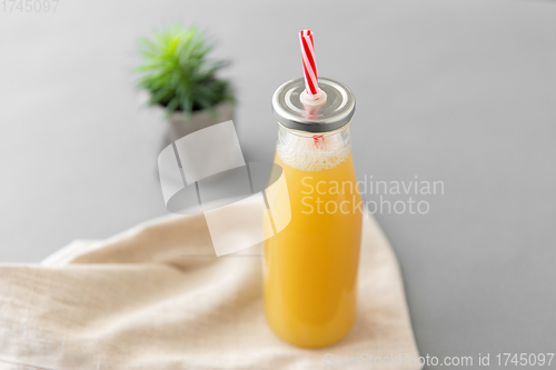 Image of reusable glass bottle of fruit juice with straw