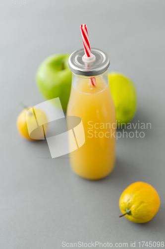 Image of reusable glass bottle of fruit juice with straw