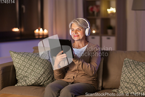 Image of senior woman in headphones listening to music